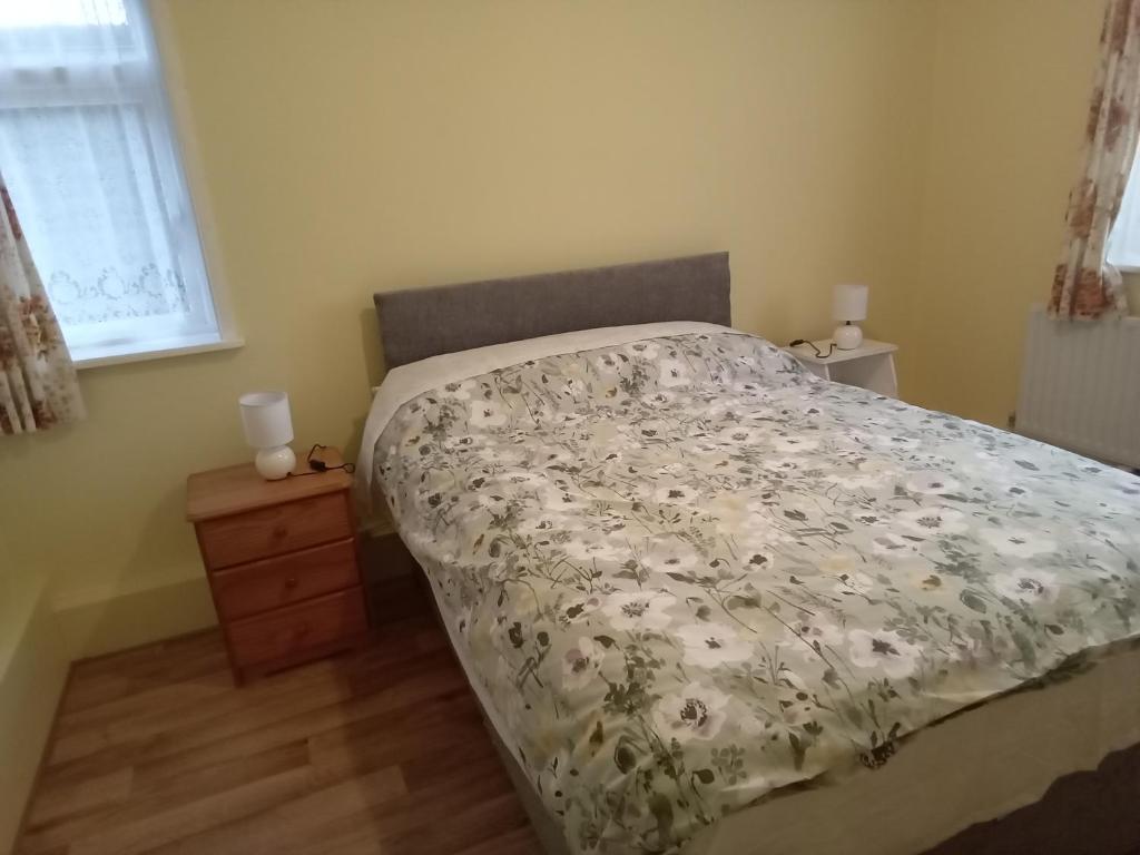 a bedroom with a bed with a floral comforter at Beech cottage 