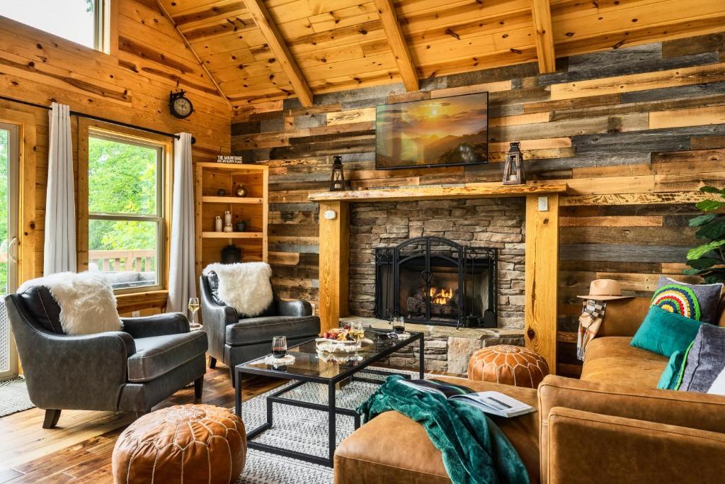 a living room with a fireplace in a log cabin at Mountainside - New Luxury Cabin-Fire Table-Hot Tub-3 Pools-PS5-Bears in Gatlinburg