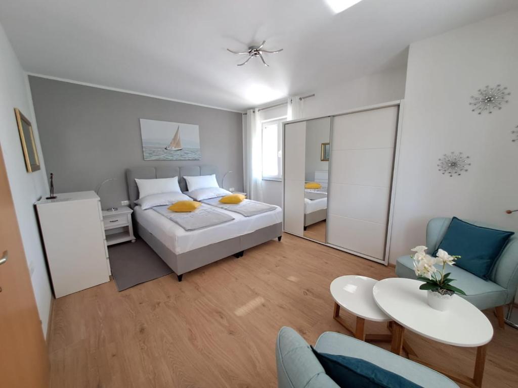 a bedroom with a bed and a living room at Kaja Apartments in Fažana