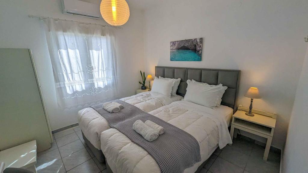 a bedroom with a large bed with two towels on it at PIANO APPARTMENT in Kampos Paros
