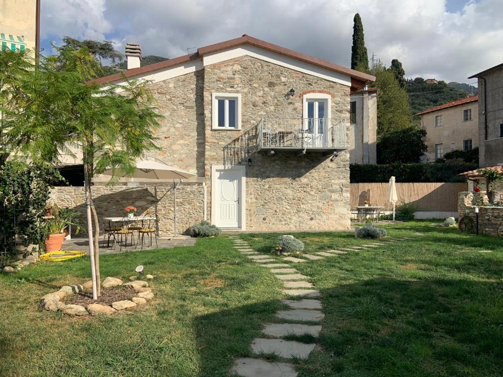 a stone house with a tree in the yard at Antica casa nel borgo in Pietrasanta