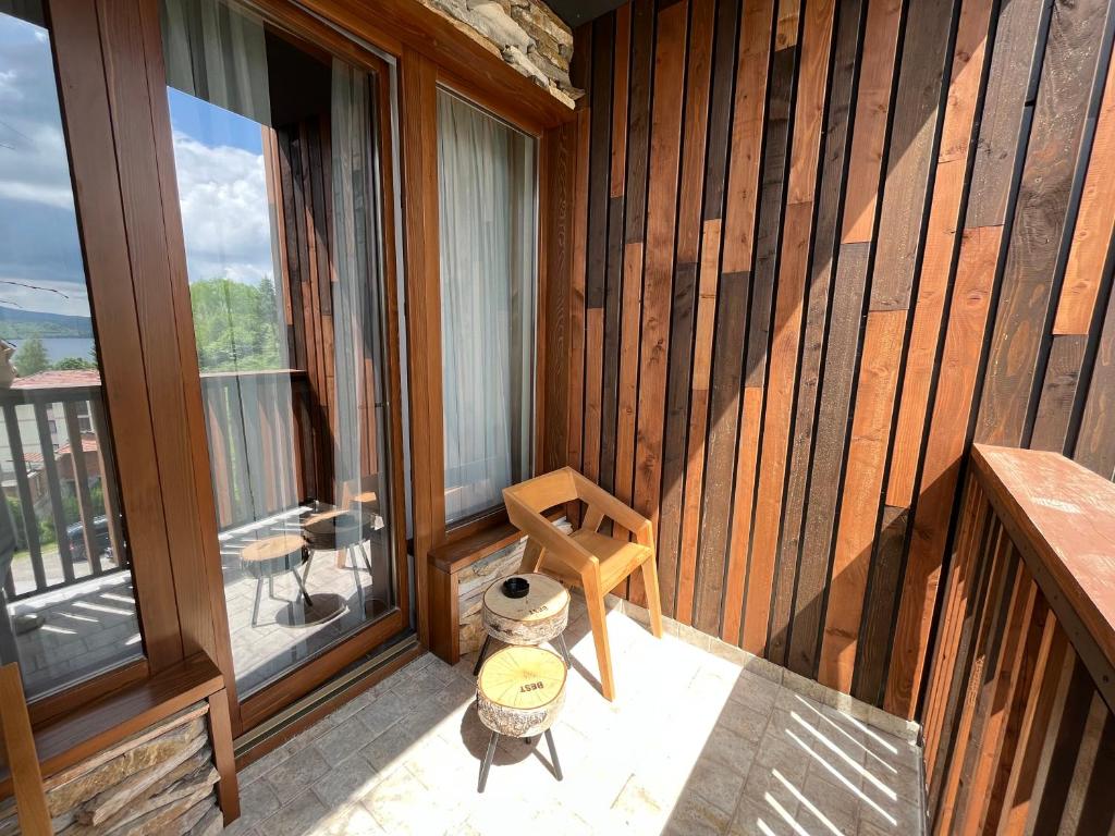 a room with a balcony with a wooden wall at Vlasinsko jezero VILA BEST in Surdulica