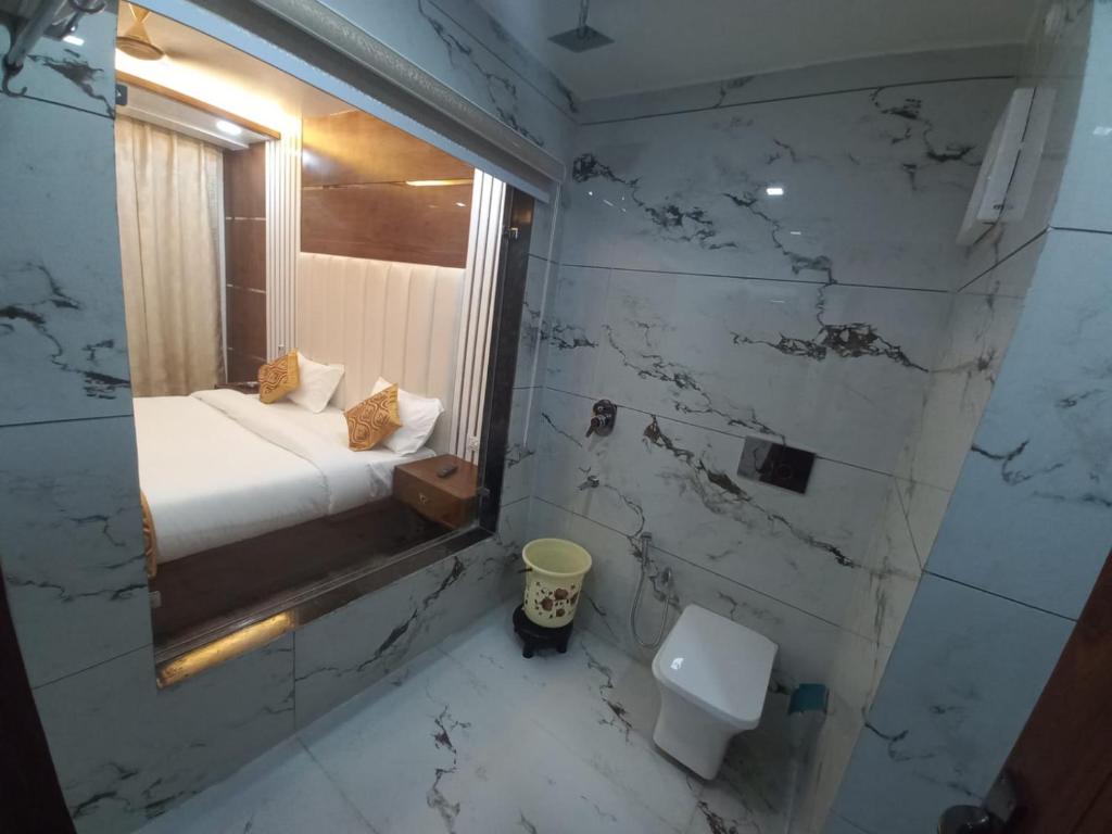 a bathroom with a bed and a window and a toilet at HOTEL TASTE OF INDIA in Agra