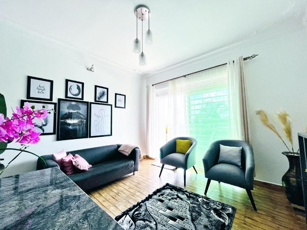 salon z niebieską kanapą i 2 krzesłami w obiekcie Apartment unit-White house with Two bedrooms w mieście Bulindo