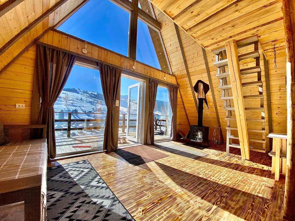 a large room with large windows in a log cabin at Файна хата 3 in Synevyrsʼka Polyana