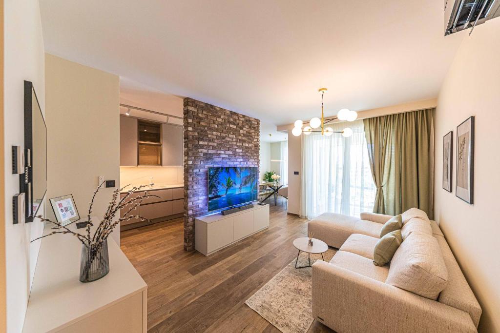 OLIVETUM luxury apartment في سبليت: غرفة معيشة مع أريكة وحوض السمك الأزرق