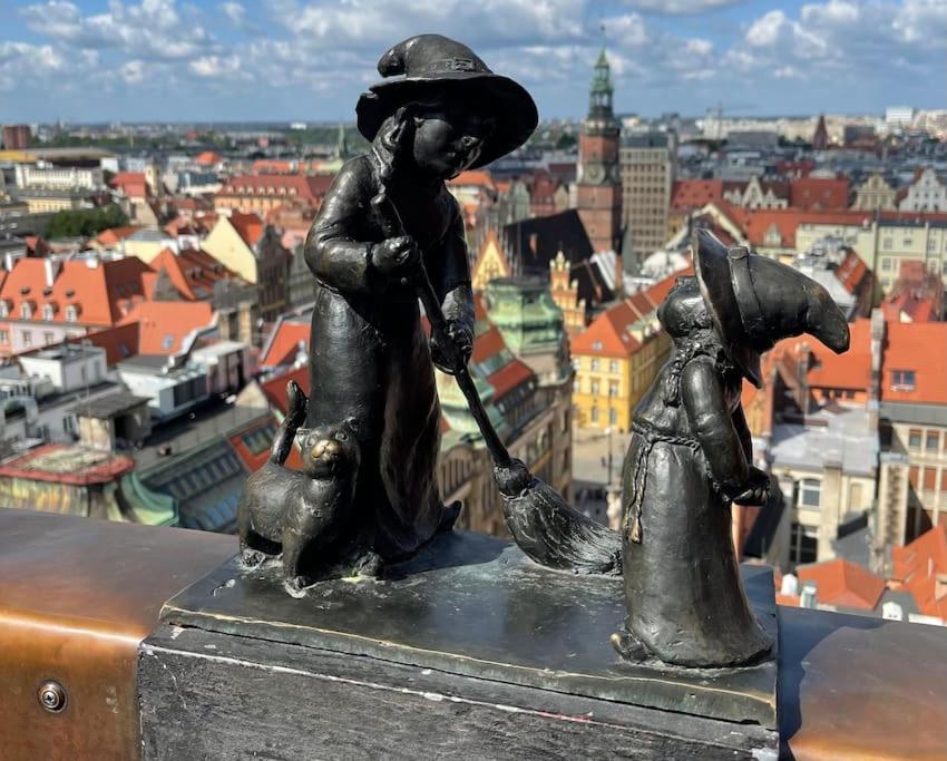 a statue of a girl and a child with a dog at Rynek pod Fredrą in Wrocław