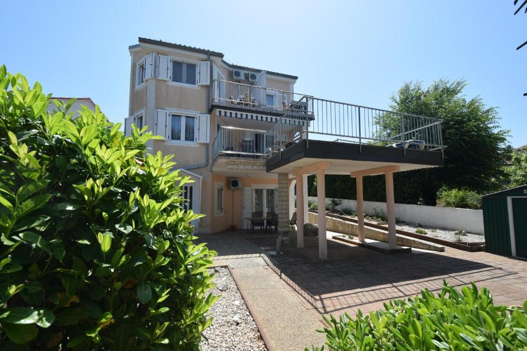 a large house with a balcony and a building at Apartments Frane in Vantačići