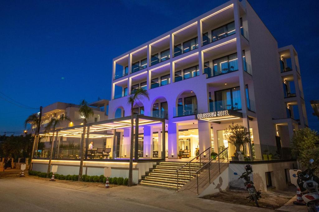 a large white building with purple lights on it at Colosseum Hotel in Ksamil