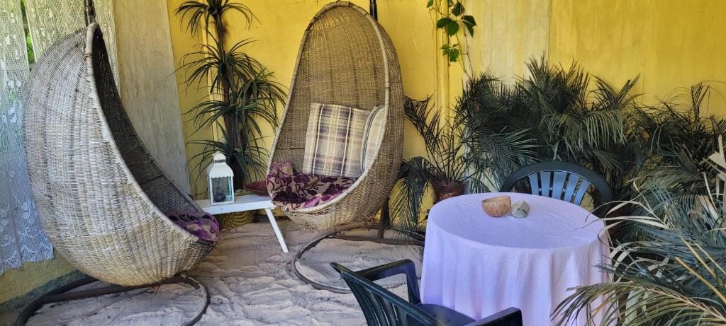 un patio con 2 hamacas colgantes, mesa y sillas en Summer bungalo trailer, en Jūrmala