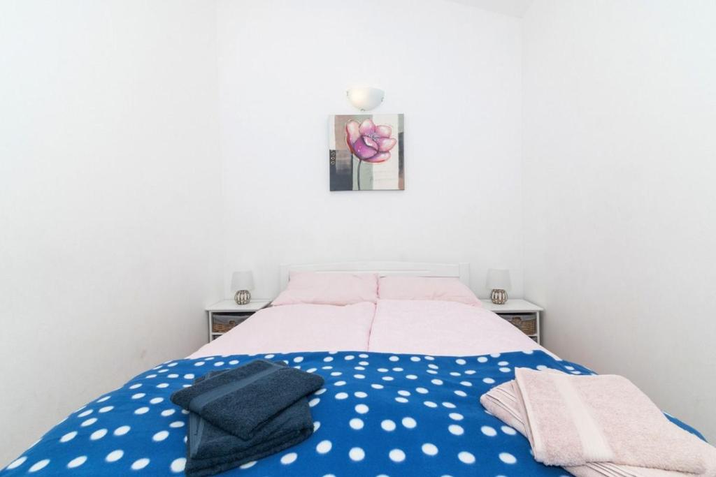 a bed with polka dot sheets and towels on it at Apartment Perla in Dinjiška
