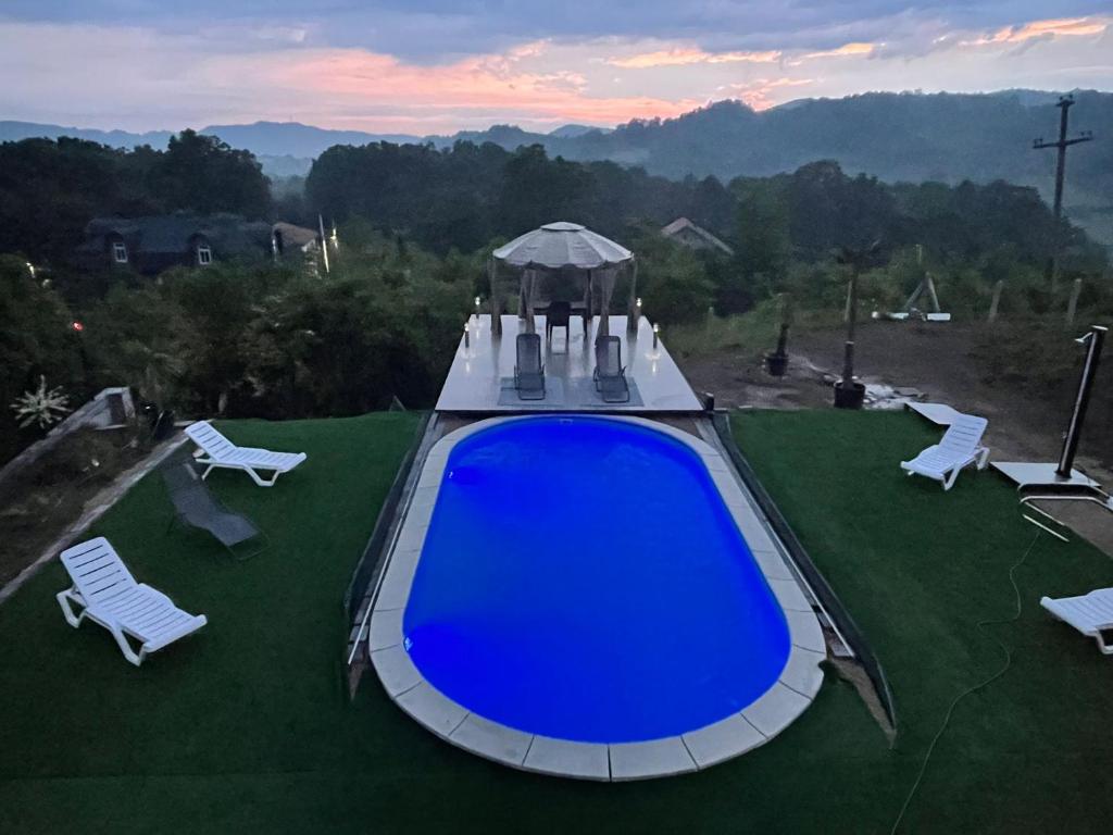 uma grande piscina azul com cadeiras e um gazebo em Elit Tuzla em Tuzla