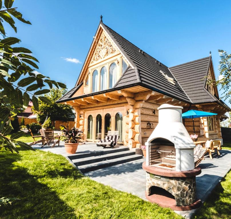 a log cabin with a fireplace in the yard at Bajkowa Chata 3 Magiczne Domki Jacuzzi in Murzasichle