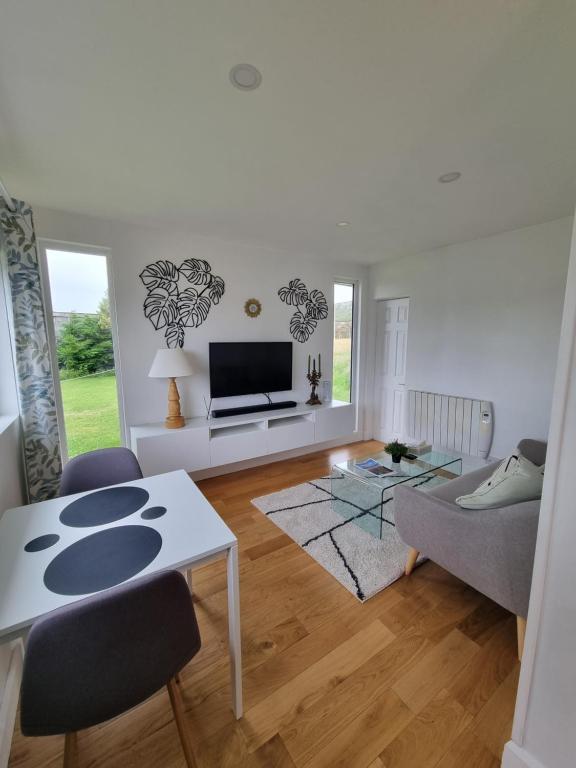 ein Wohnzimmer mit einem Tisch und einem TV in der Unterkunft Vimy House in Clifden