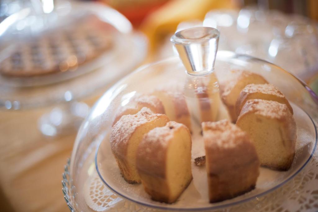 a glass plate with cakes on a table at La Rosa dei Venti B&B in Chia