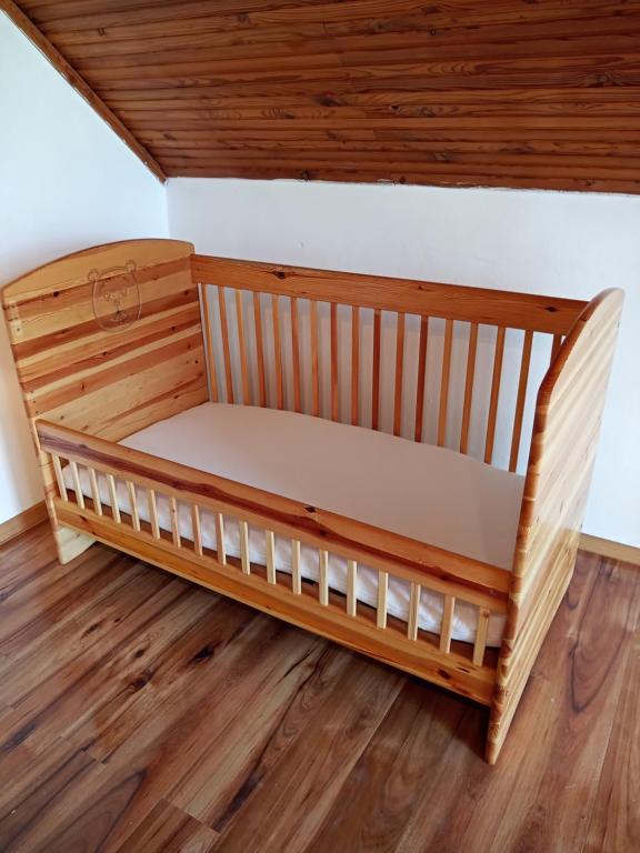 uma cama de madeira num quarto com piso de madeira em Balaton Panorama em Balatonfüred