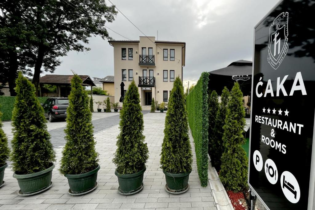 rząd drzew doniczkowych przed budynkiem w obiekcie ĆAKA Luxury Rooms & Restaurant w mieście Ćuprija