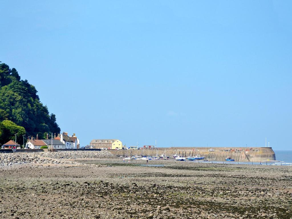 a beach with boats in the water and a group of houses at Walnuts Nest in Minehead