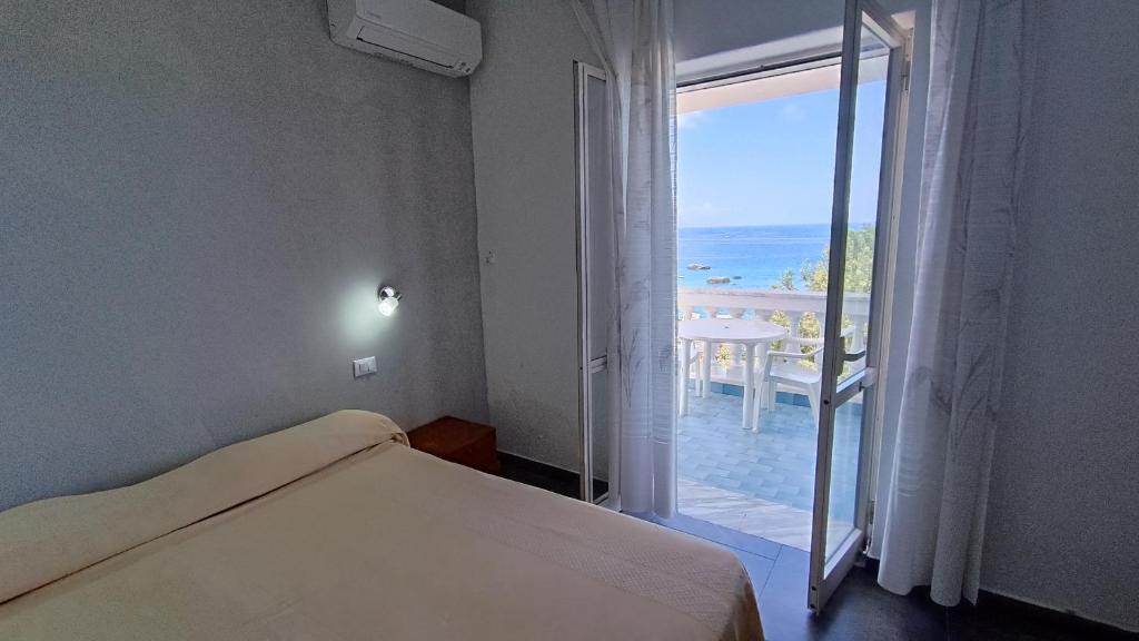 1 dormitorio con cama y vistas al océano en La Dea del Mare, en Isquia