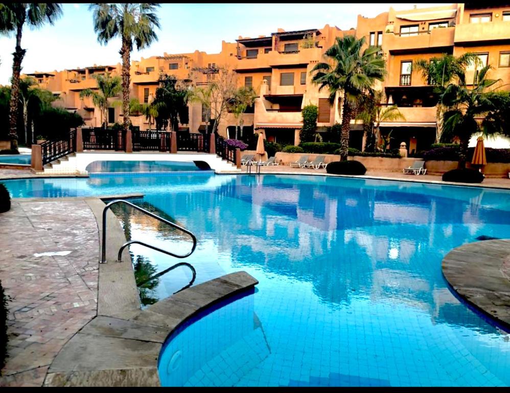 una grande piscina con acqua blu in un resort di Villa Agdal a Marrakech