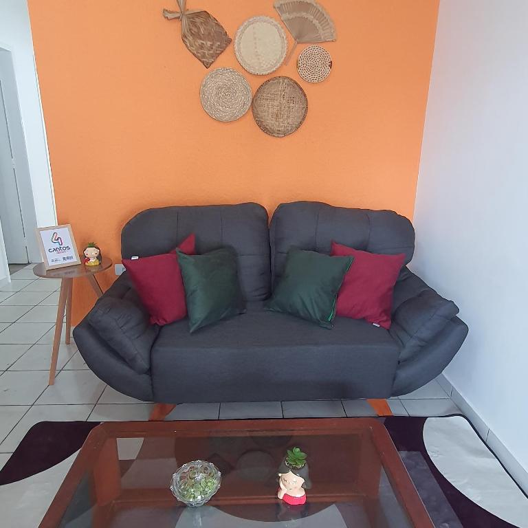 a blue couch with colorful pillows in a living room at Casa de Campina in Campina Grande