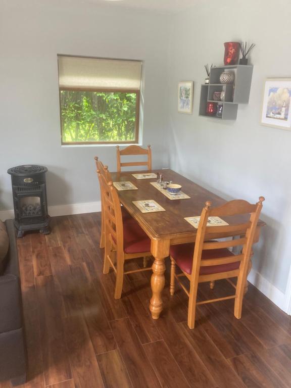 a dining room with a wooden table and chairs at Copper rose guest house 