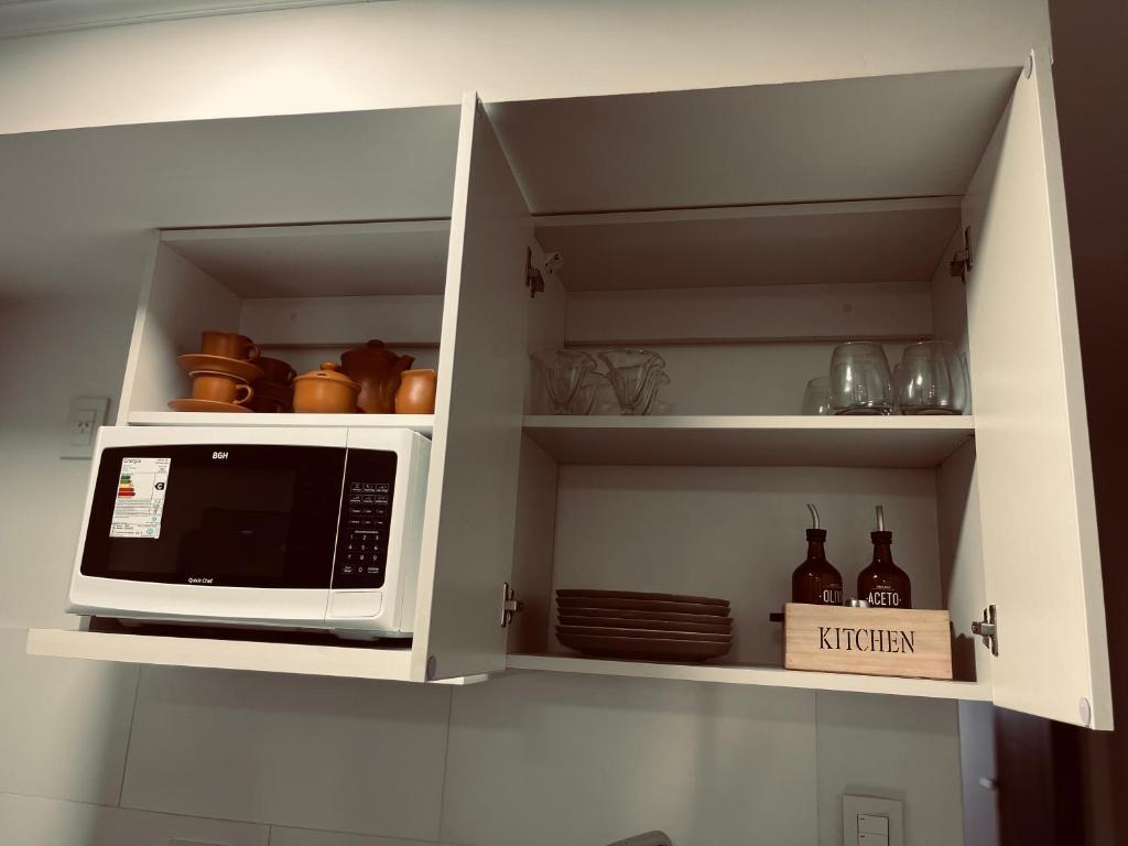 a kitchen with a microwave in a white cabinet at ALQUILER TEMPORARIO VALENTINA in Resistencia