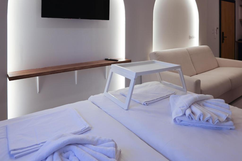 a room with a bed with a table and a couch at Uphill Unique Boutique Suites in Skiathos