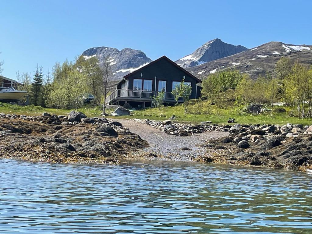 a house on the shore of a body of water at Sildpollnes Lodge in Laupstad