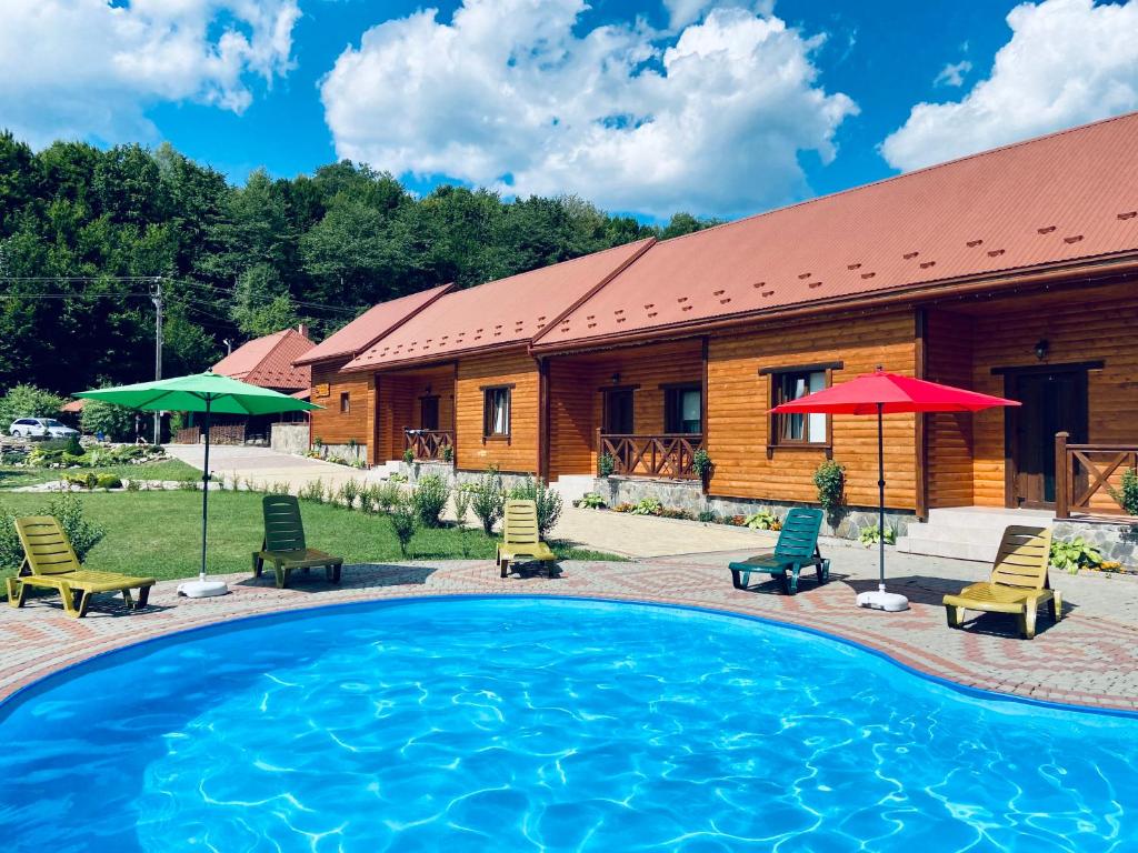 a resort with a swimming pool and a house at Перлина Лумшор in Lumshory