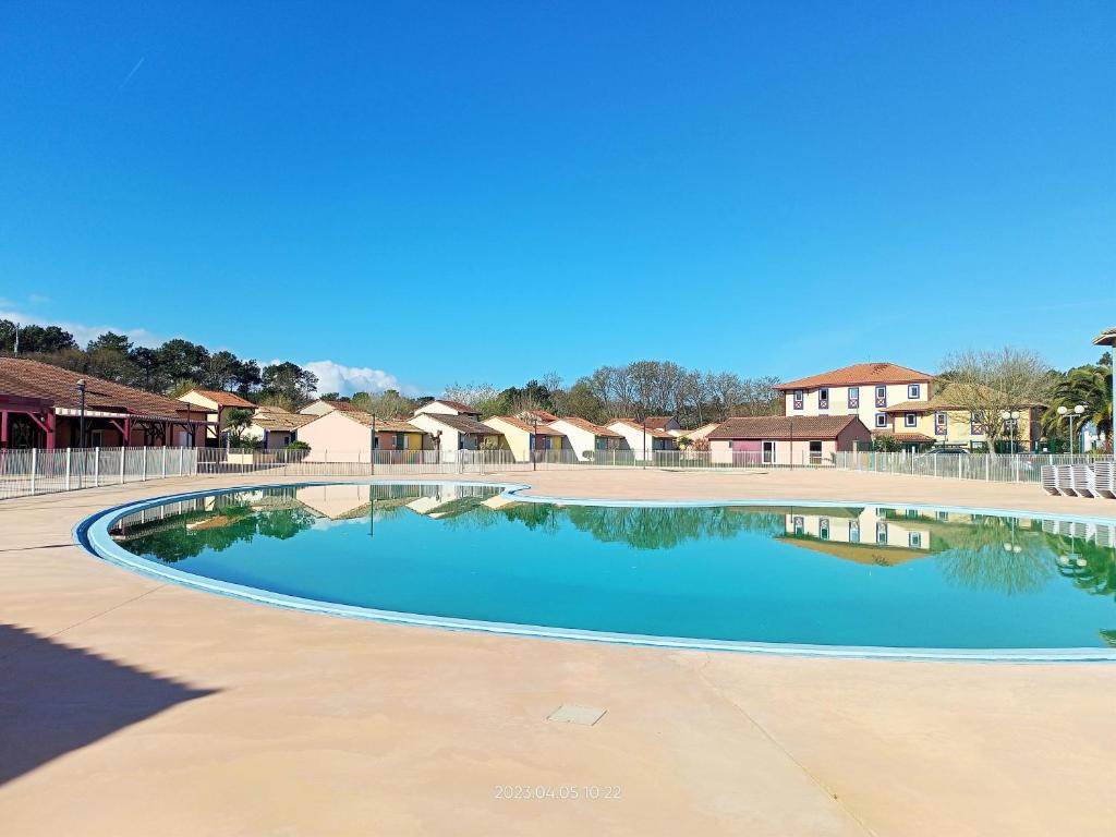 uma grande piscina com edifícios ao fundo em Pavillon Soustons Plage em Soustons