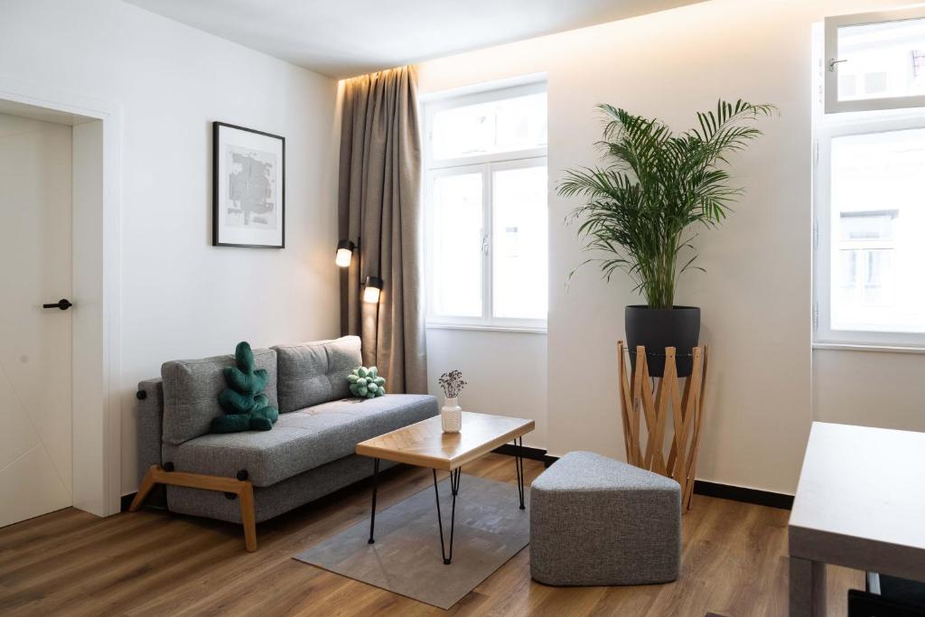 a living room with a couch and a table at Urban Jungle Apartments in Vienna