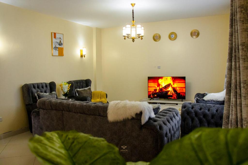 uma sala de estar com dois sofás e uma lareira em Nairobi nest apartments em Nairobi