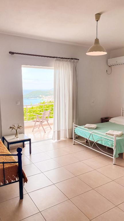 a bedroom with a bed and a view of the ocean at ELÉA Guesthouse himare in Himare