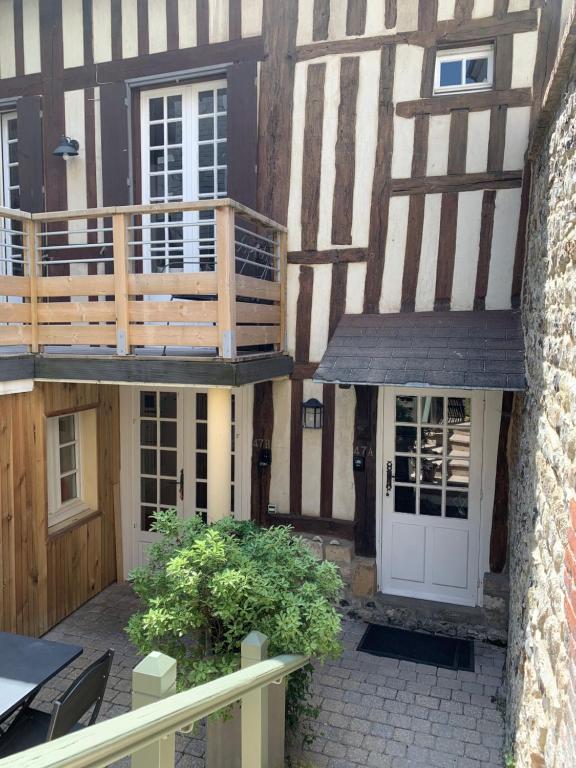 Ce bâtiment ancien dispose d'une terrasse couverte et d'une porte blanche. dans l'établissement Honfleur effet mer 2, à Honfleur
