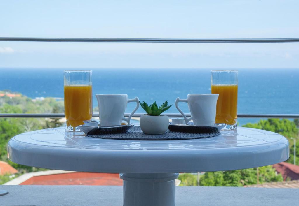 une table bleue avec deux tasses et deux verres de jus d'orange dans l'établissement Black sea Narcissus - quiet studio with amazing sea view, à Varna