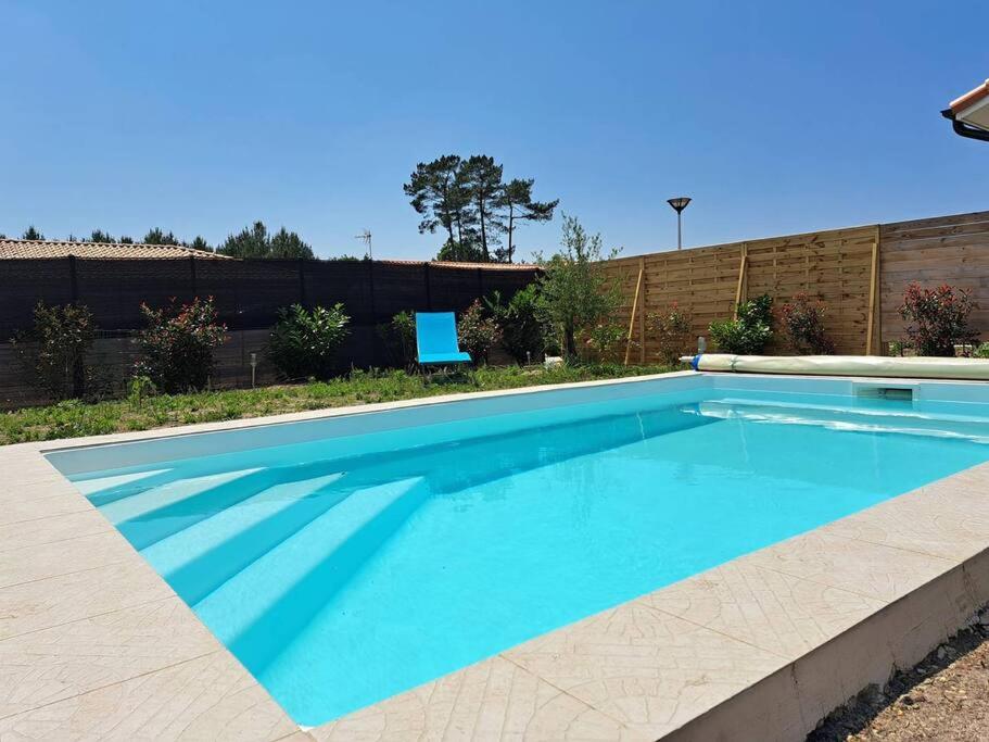 una grande piscina con acqua blu in un cortile di TURQUOISE a Linxe
