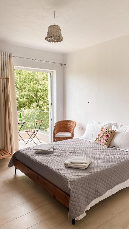 a bedroom with a large bed and a window at ELÉA Guesthouse himare in Himare