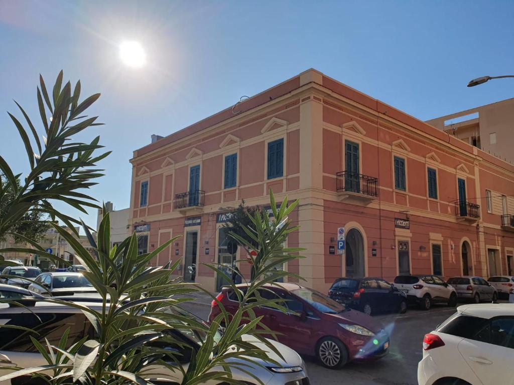 a building with cars parked in a parking lot at Le Case di Franca in Trapani