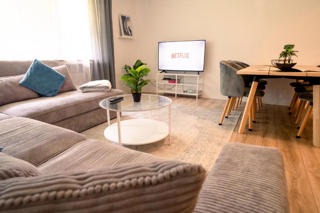 a living room with a couch and a table and a tv at TRUTH - Kingsize Bett - Smart TV - Modern - Top Anbindung in Dortmund