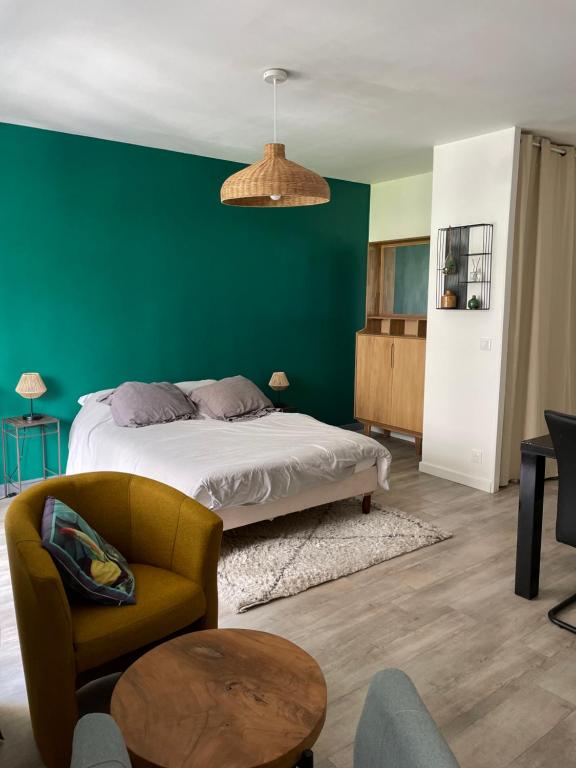 1 dormitorio con cama y pared verde en Studio hypercentre 27m2 avec balcon et parking, en Aix-les-Bains