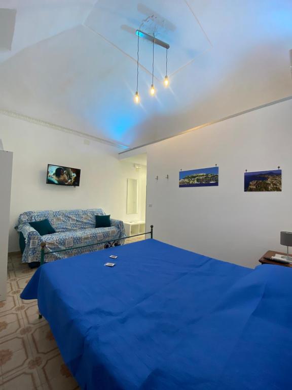 una camera con un letto blu e un divano di La Casetta dei Sogni a Procida