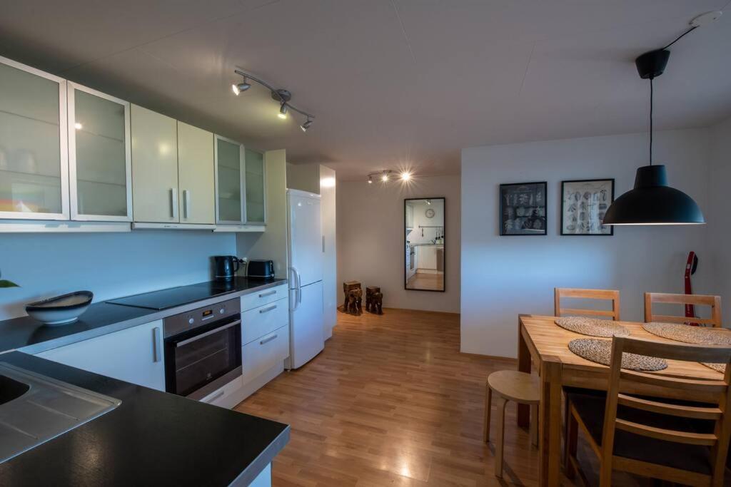 a kitchen with a table and a dining room at Lovely one bedroom apartment in Hafnarfjordur in Hafnarfjördur