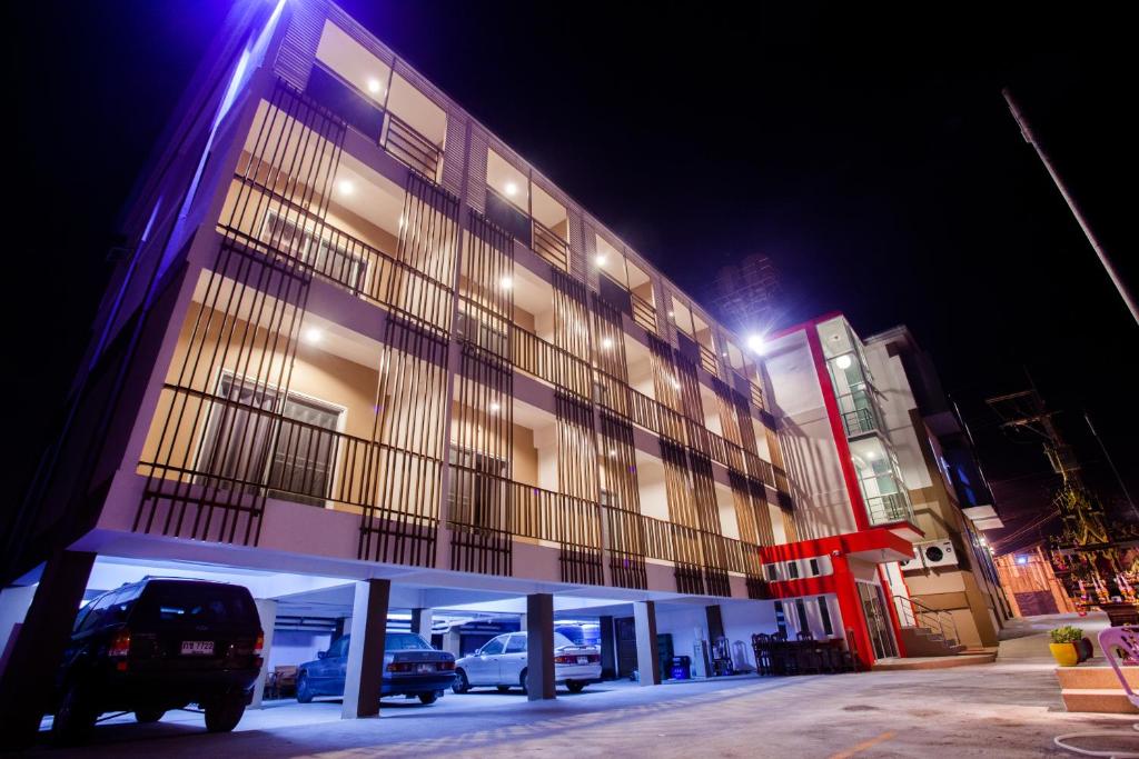 een gebouw waar 's nachts auto's buiten geparkeerd staan bij Smile Place in Chiang Rai
