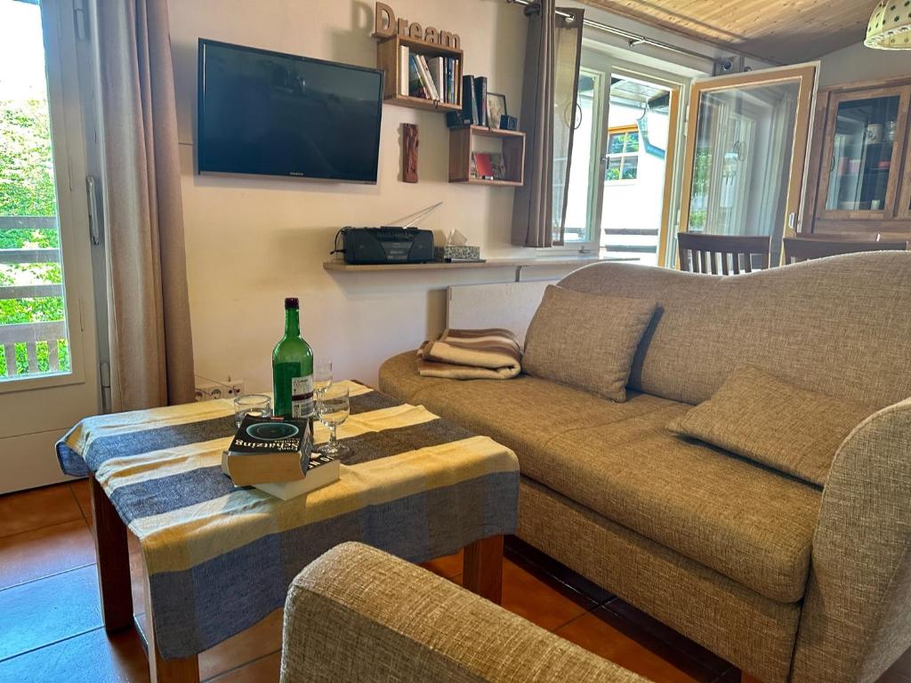 una sala de estar con sofá y una botella de vino en una mesa en Ferienwohnungen Hänsel und Gretel - zentral, gemütlich, nah am See, en Schliersee