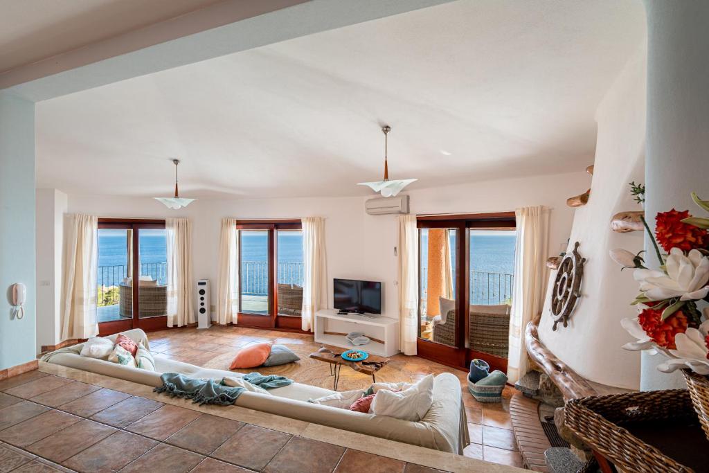 a living room with two couches and a television at Vista mozzafiato a picco sul mare Villa Patty in Torre delle Stelle