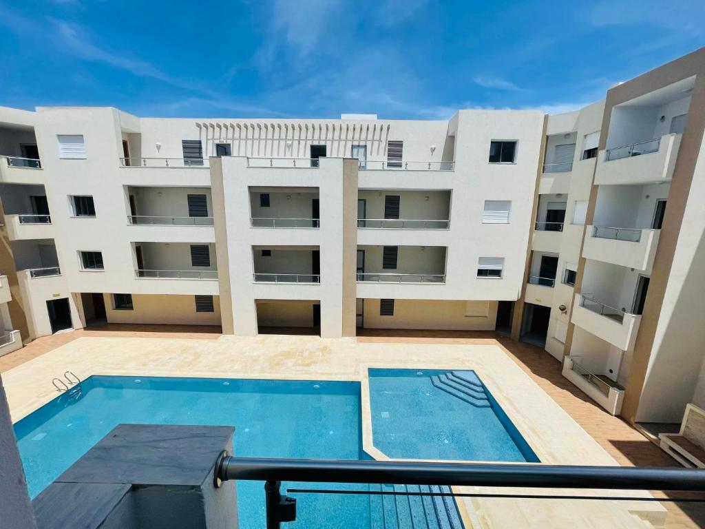 widok na duży budynek apartamentowy z basenem w obiekcie Luxus-Apartment mit Poolblick w mieście Kelibia