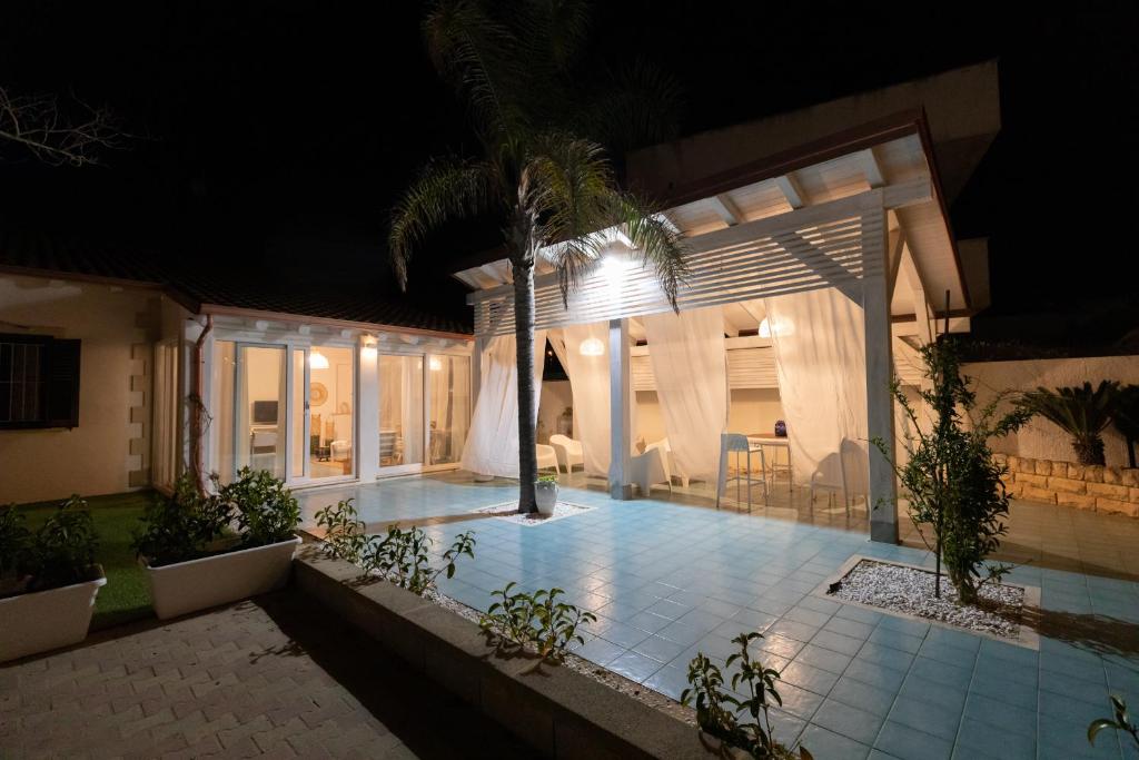 une maison avec une piscine la nuit dans l'établissement SICILY SUN CON ACCESSO SPIAGGIA, à Santa Maria Del Focallo