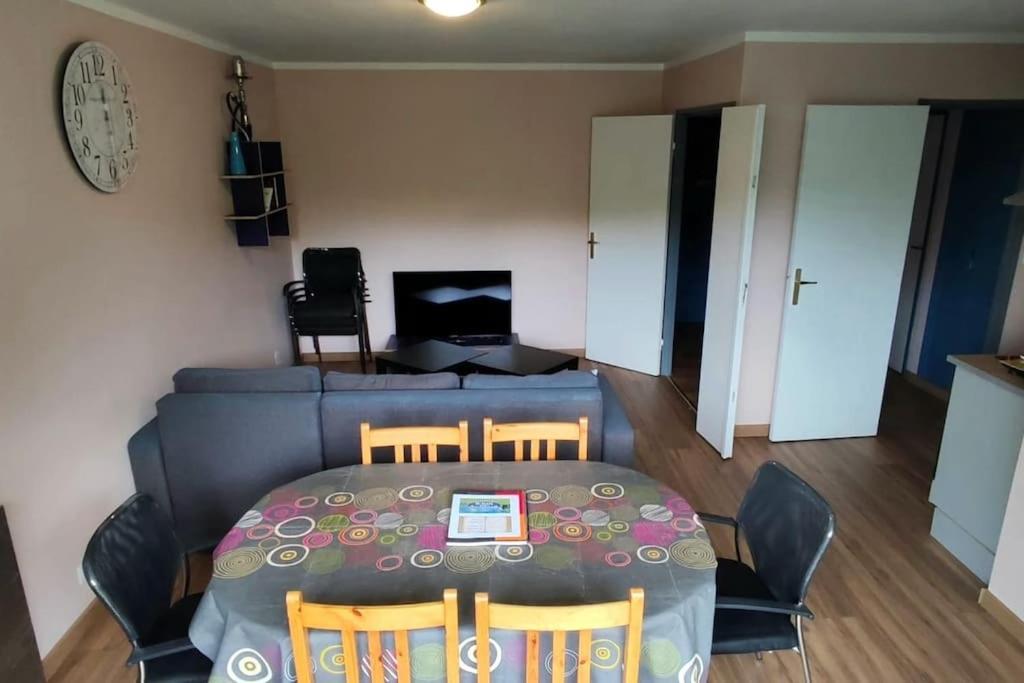una sala de estar con una mesa y un sofá en Appartement Grand Paris, en Saint-Denis