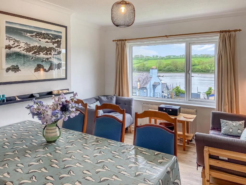 a living room with a table and chairs and a window at Ferry View in Cardigan